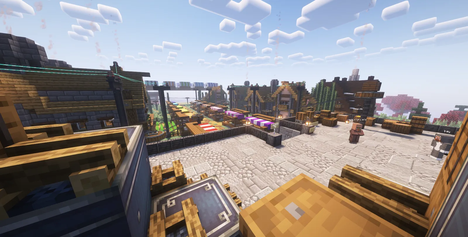 The market square seen from a rooftop: striped stalls, a cable line and a villager