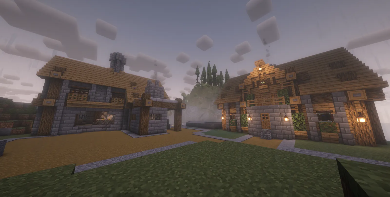 Two stone and timber houses on a misty, rainy evening